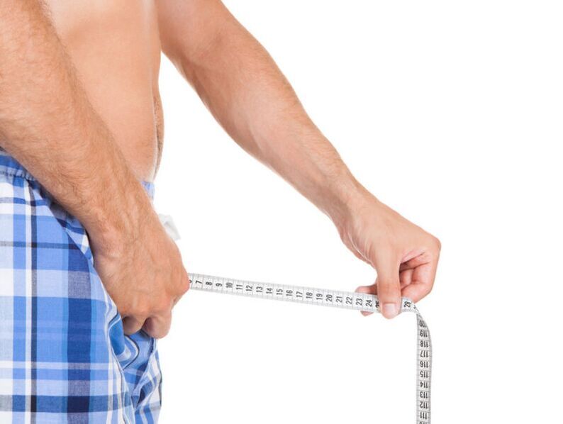 uomo che misura il suo pene con un centimetro